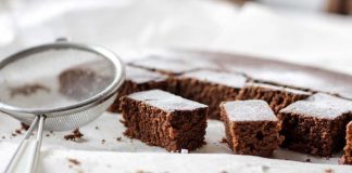 Black Forest Passover Brownies being dusted with powdered sugar.