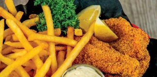 Fried Catfish in a basket with fries and lemon wedges