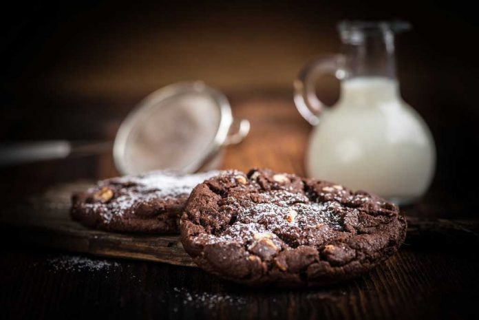 Cocoa Chocolate Chip Cookies Cocoa Chocolate Chip Cookies with a pitcher of milk and a sifter in the background.