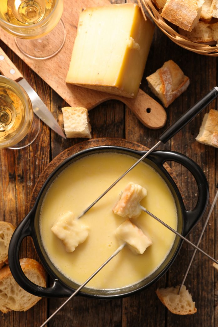 Seafood Cheese Fondue Dipping bread into the Seafood Cheese Fondue pot.