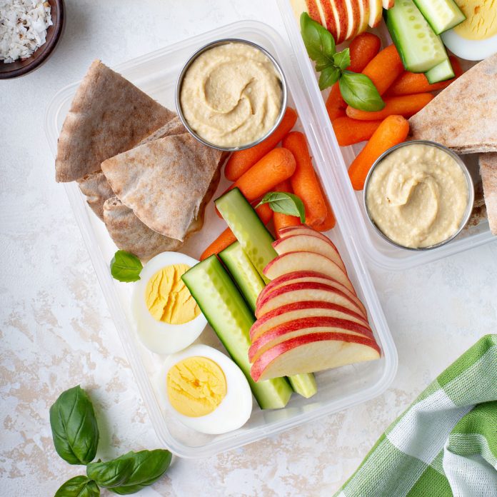 hummus-web Hummus packed with fruits and vegetables for a school lunch.