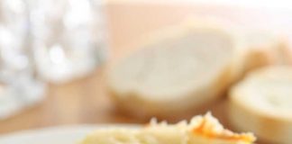 A piece of Four Cheese Spinach Lasagna on a white dinner plate.