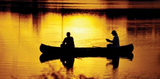 two men fishing in a canoe