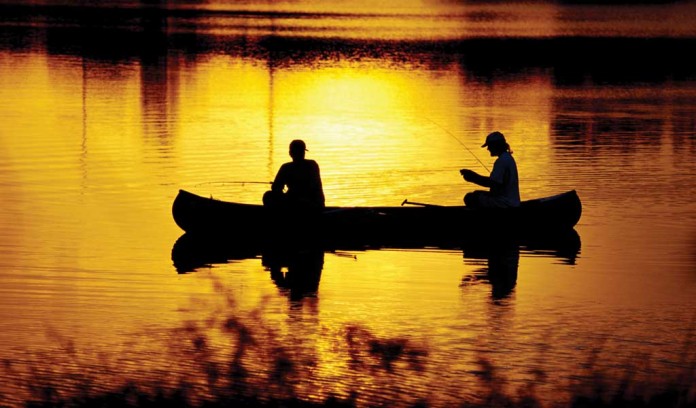 two men fishing in a canoe two men fishing in a canoe