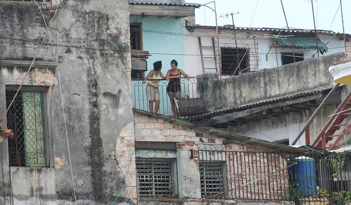 women on balcony Havana buildings
