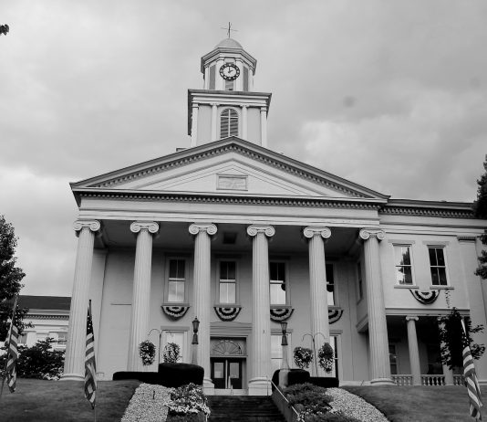 The tall clock tower and looming white pillars of the Lawrence County, Pennsylvania Courthouse stands tall against the cloudy sky as another day in Drug Court begins.