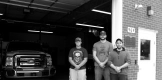 Three volunteer North Beaver Firefighters and Rescue workers stand in front of their station.