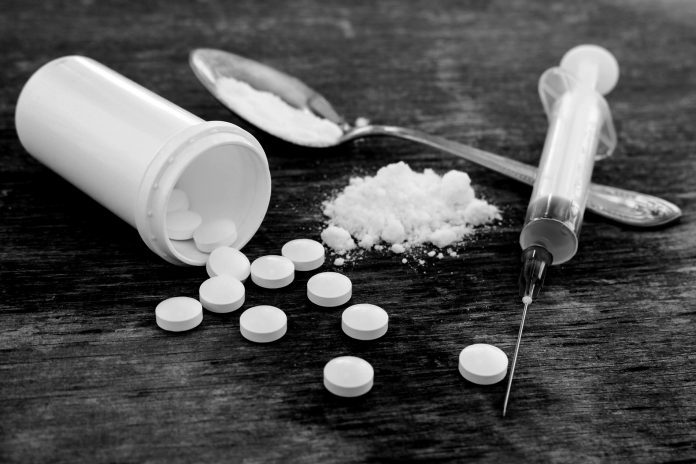 About Opioids Pills, Fentynal Powder, and Heroin syringe sit on a table