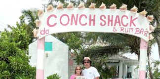 The Willoughbys at the entrance to Da Conch Shack on Turks and Caicos holding a Farm and Dairy Newspaper