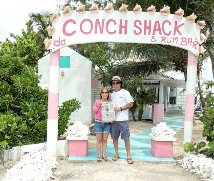 vac-willoughby The Willoughbys at the entrance to Da Conch Shack on Turks and Caicos holding a Farm and Dairy Newspaper