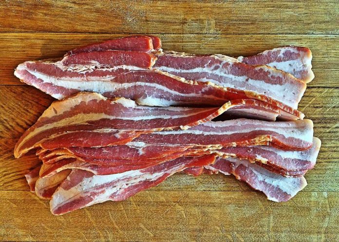Bacon Bacon layed out on a cutting board to be chopped into pieces for Pigskin Bites