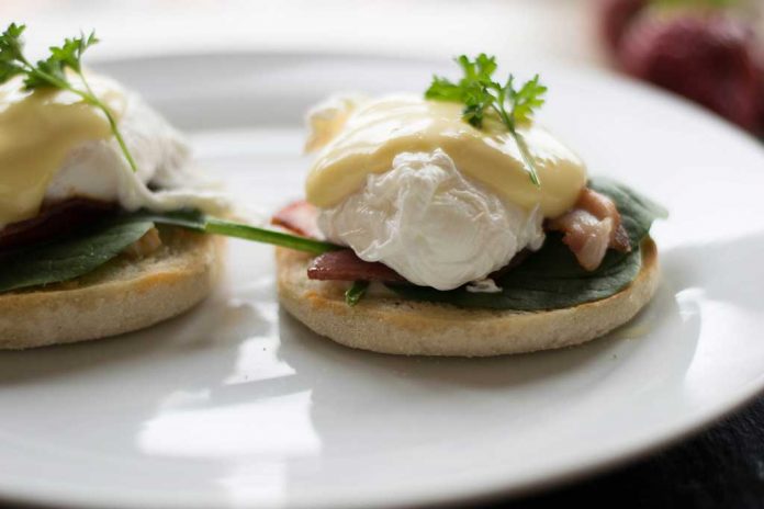 Hollandaise Sauce Hollandaise Sauce over poached eggs, spinach, and bacon on an english muffin