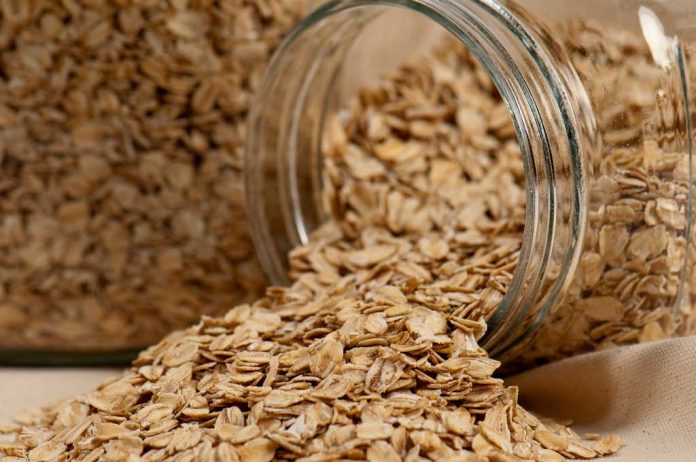 Chocolate Oat Bar Ingredients Rolled oats in a jar spilled onto the counter.