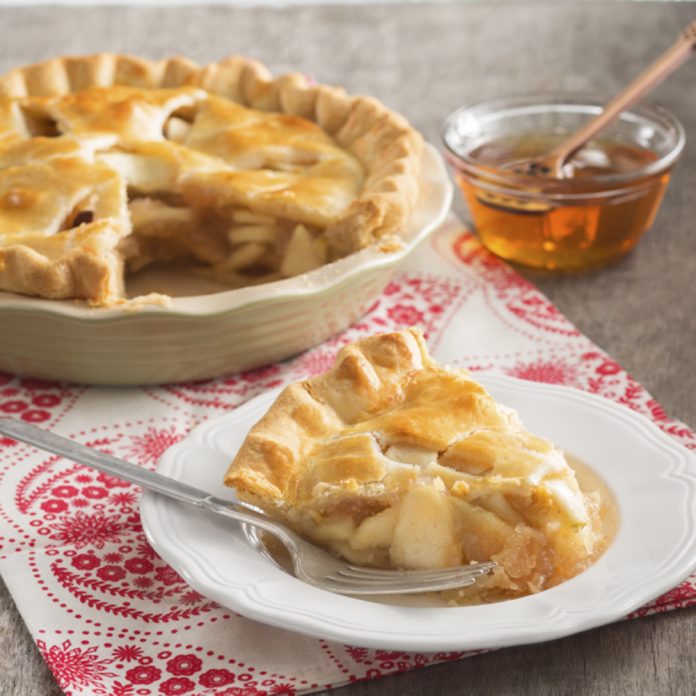 Queen Bee Apple Pie A slice of Queen Bee Apple Pie on a white plate.