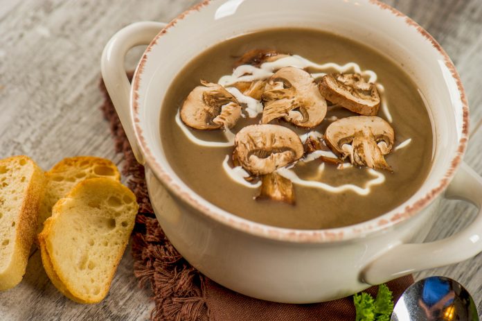 feature.web A bowl of Wild Mushroom Soup with a side of toasted crostinis.