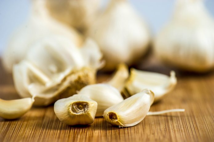 feature.web Garlic cloves on a cutting block.