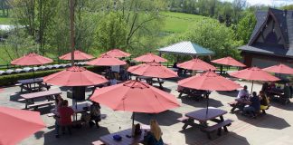 People sit at picnic tables under umbrellas.