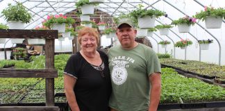 cathy and ken metrick stand in greenhouse