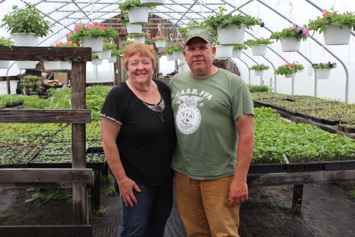 metricks-1 cathy and ken metrick stand in greenhouse
