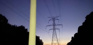 Fluorescent bulb glowing under power lines