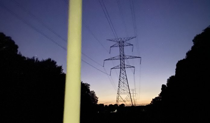 Fluorescent bulb glowing under power lines Fluorescent bulb glowing under power lines