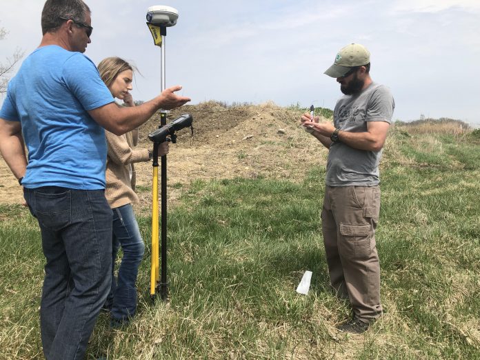 ashland_swcd_of_the_year_6 Three people stand in a field with GPS surveying equipment.