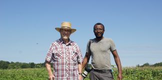 Two men stand in a field.