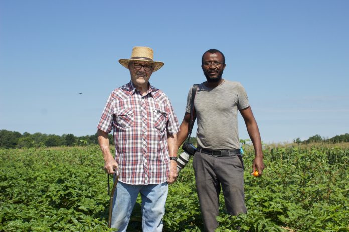 chernor_bundu_profile_1 Two men stand in a field.