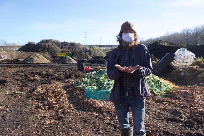 rust_belt_riders_4 A man stands in front of a composting facility.