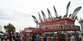 People walk around in front of concession stands at the Canfield Fair.