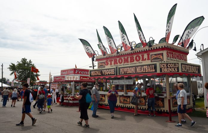 Canfield Fair People walk around in front of concession stands at the Canfield Fair.