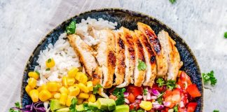 A bowl of food with rice, vegetables and protein.