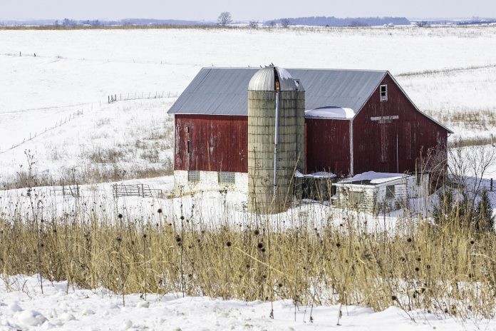 metrobarn A barn and silo in the winter, with snow on the ground.