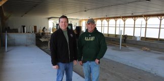 men standing in new free stall barn