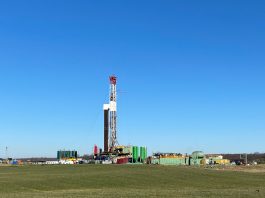 an unconventional oil and gas drilling rig sits in a green field in eastern Ohio