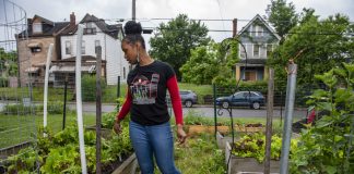 A woman stands in a garden at a community farm, in Pittsburgh.