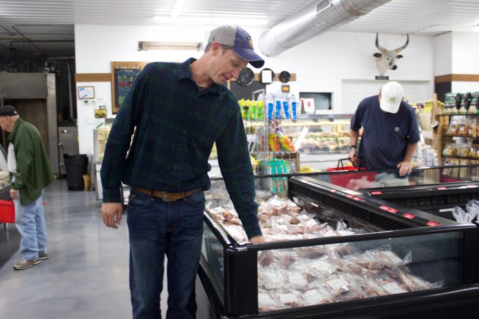 honeytown_meats_2 A man looks over cuts of meat in a store.