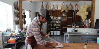 guy wrapping up meat on a table