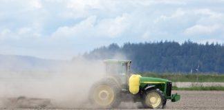 tractor stirring up dust in a field