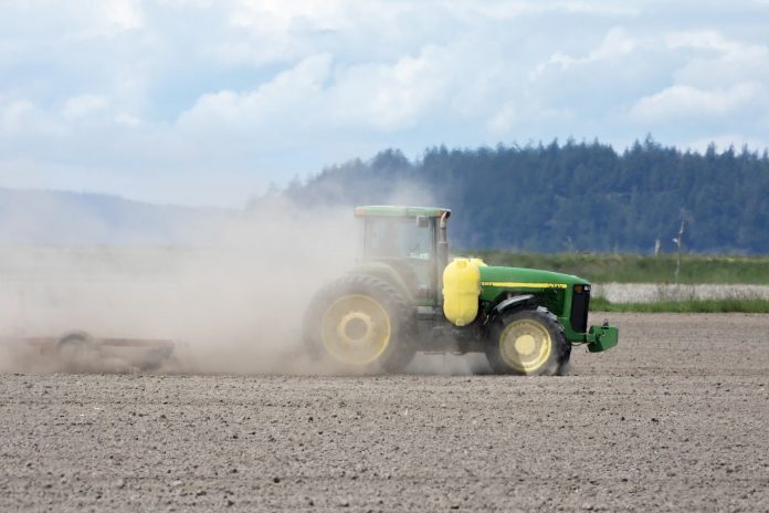 tractor stirring up dust in a field tractor stirring up dust in a field