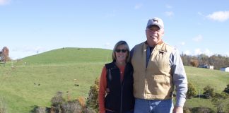 Two people stand on a farm.