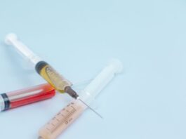 white and orange syringe on white surface