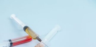 white and orange syringe on white surface