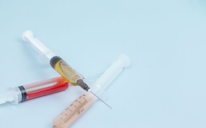 Photo by Diana Polekhina white and orange syringe on white surface