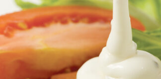 Ranch dresing pouring over a salad.