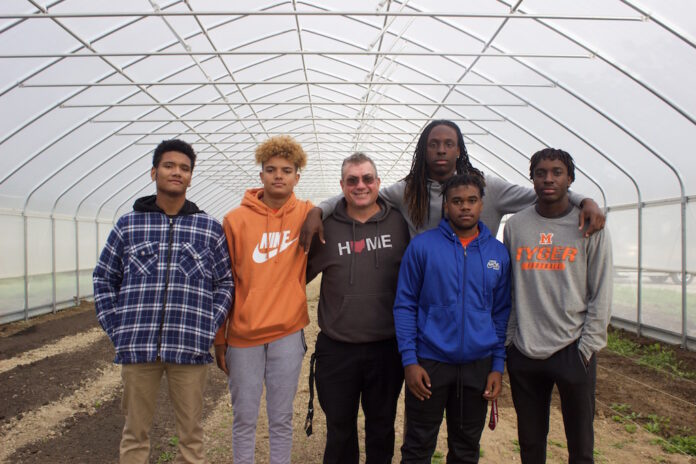 mansfield_career_tech_agribusiness_1 Five students and a teacher stand in a high tunnel