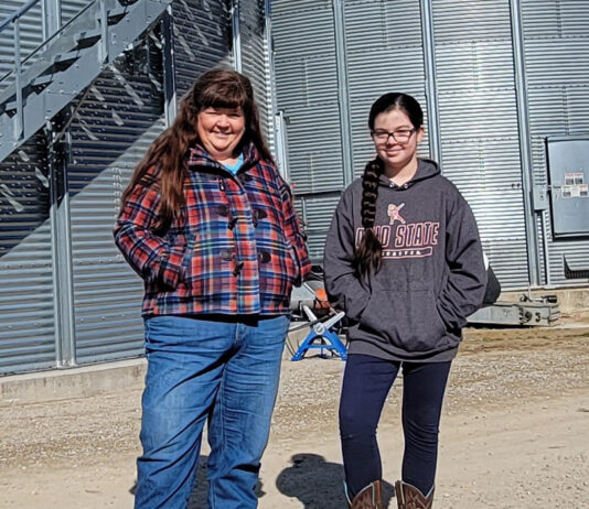 Marcia and Mae Ruff stand in front of grain containers, Feb. 11. The containers were built in partnership with Farmers Business Network.