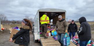 people carry donated items out of a trailer