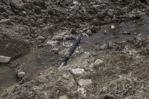 A pipeline sits unearthed in a small ditch that runs through Steve and Shawn Kacerski's field.