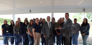 a group of teachers stand together to receive an award